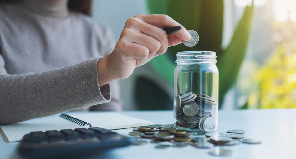 A child putting money in a jar.