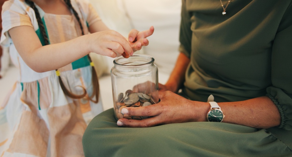 A child counting money in a jar.