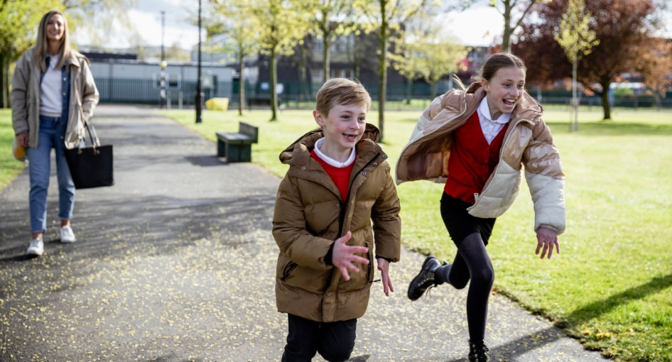 A mum and two children walking home from school.