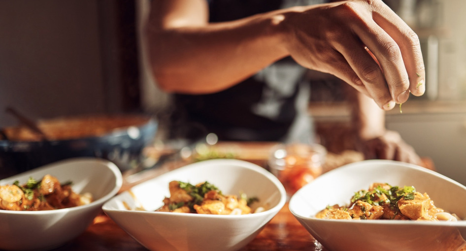 A man adding garnishes to a meal.